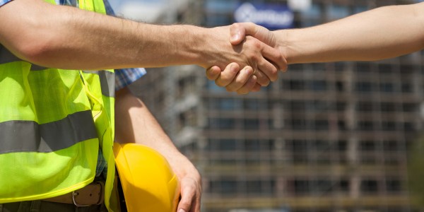 Architects shaking hand at construction site