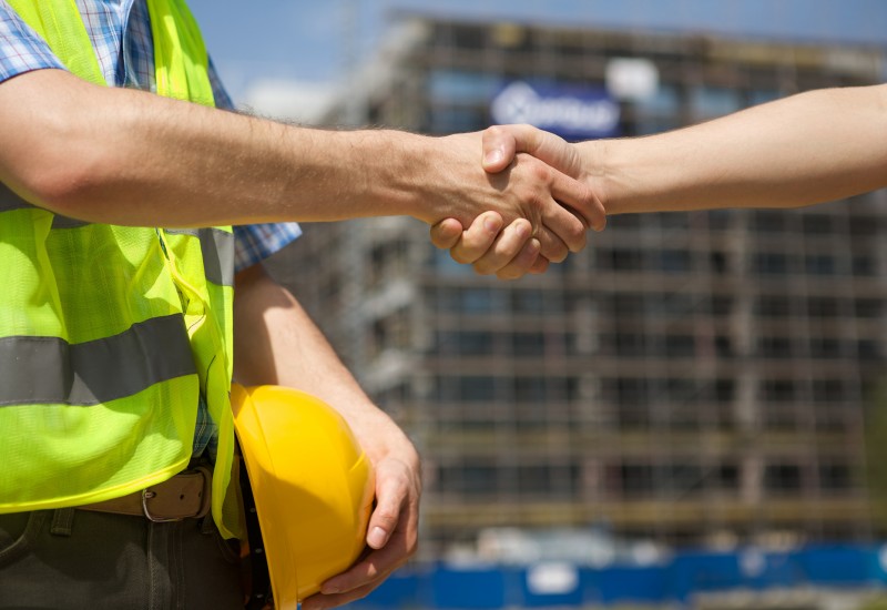 Architects shaking hand at construction site